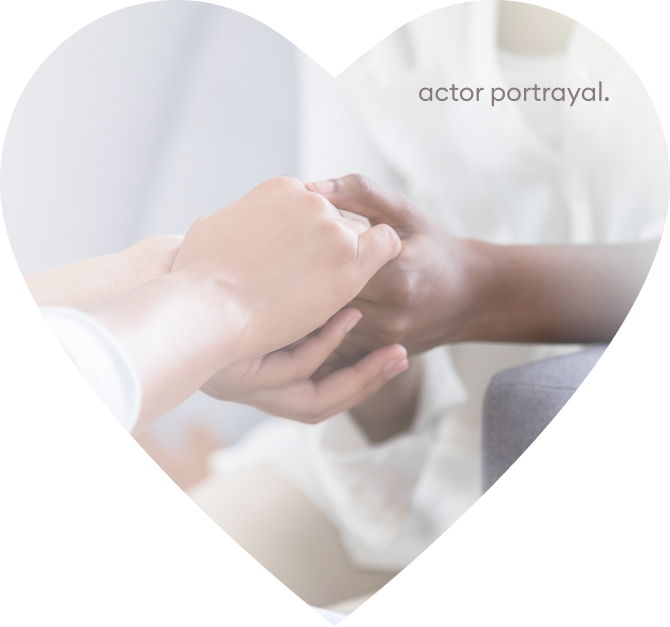 A photo of a pair of hands holding someone else’s hand inside a heart shape